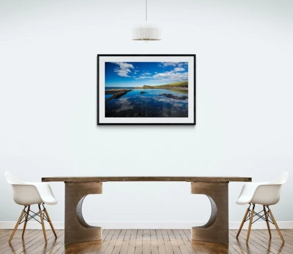 An impossibly blue sky reflects in an ocean rock pool. Framed in black