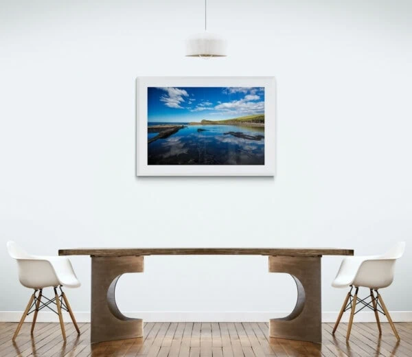 An impossibly blue sky reflects in an ocean rock pool. Framed in white