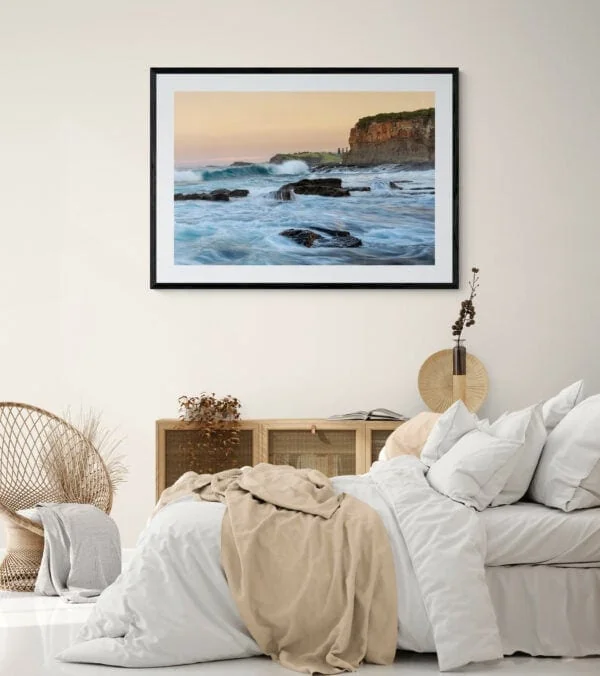 Surging ocean waters and headlands at sunset. Framed in black