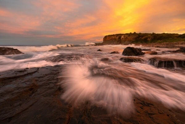 Fire Spray - Sunset lights up the endless movement of water on the Kiama Coast Walk, Australia