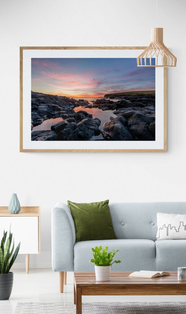 Sunrise view of the rocks and water of Loves Bay. Framed in Tasmanian oak