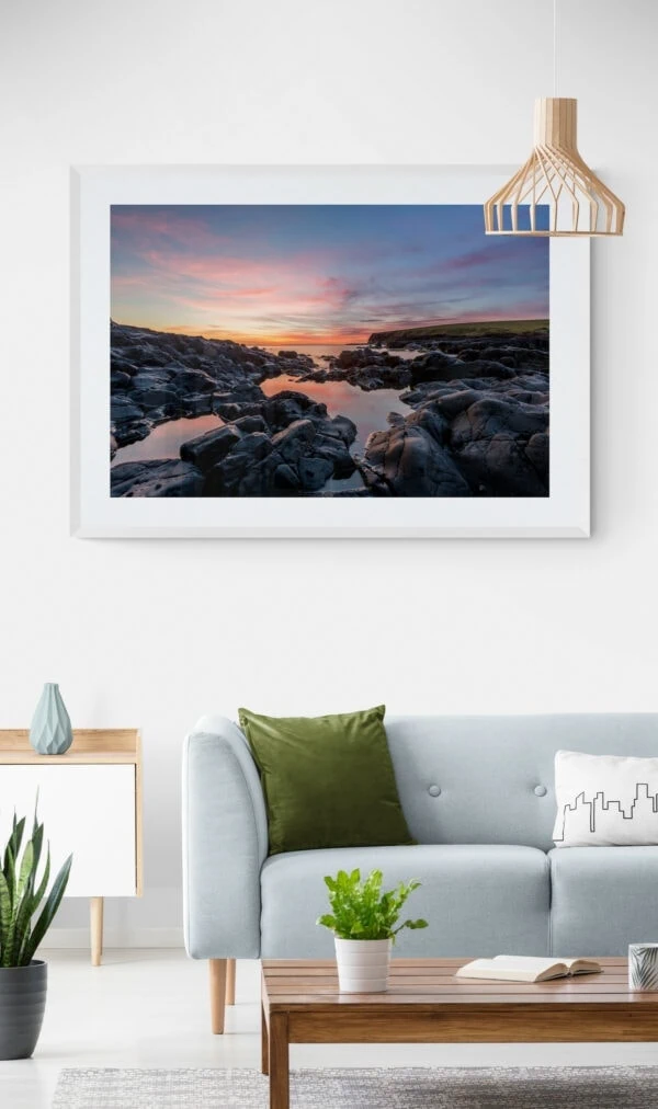 Sunrise view of the rocks and water of Loves Bay. Framed in white
